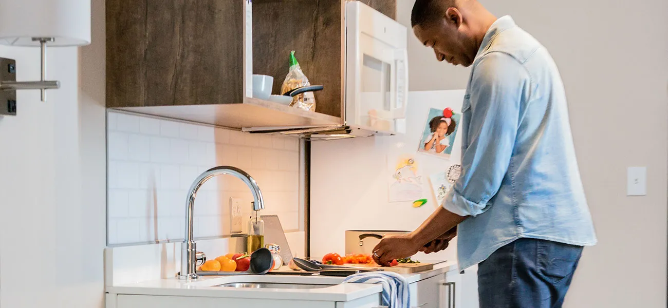 Man chopping tomatoes in hotel room