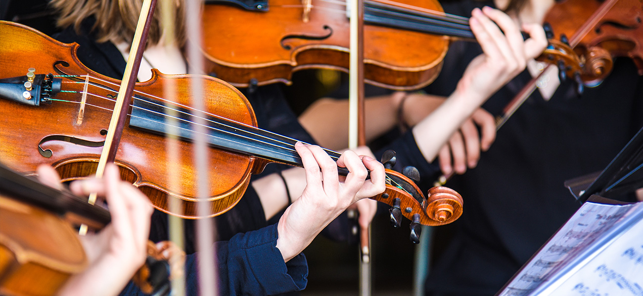 Orchestra members playing violins.