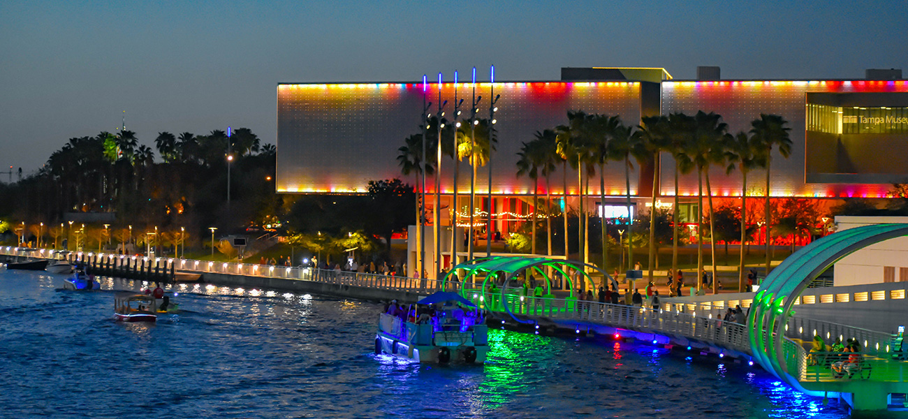 The Tampa Museum of Art, lit up at night, alongside the Riverwalk.