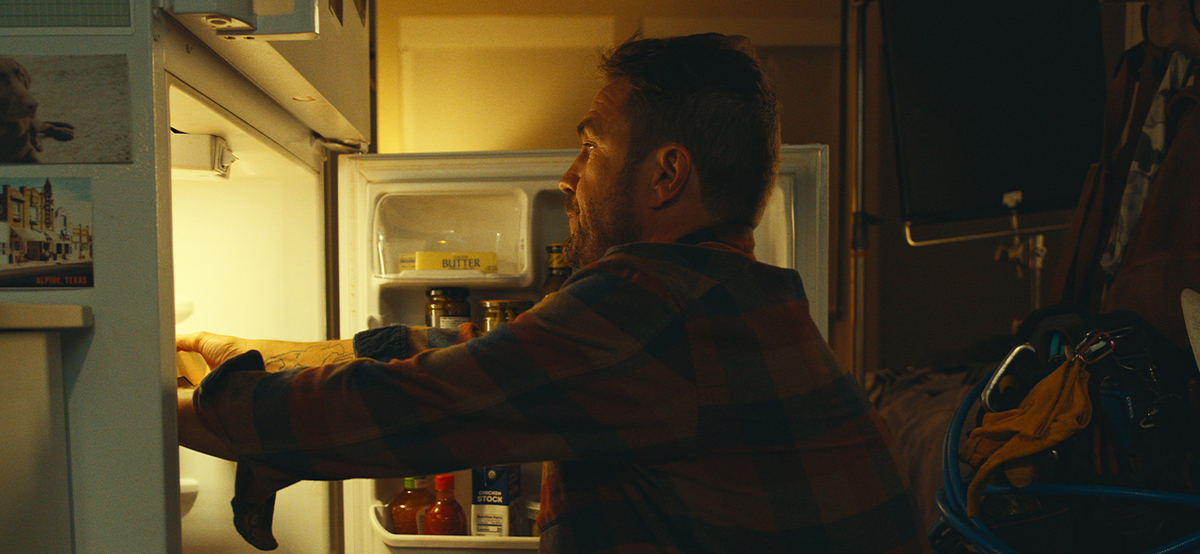 man getting leftovers out of fridge
