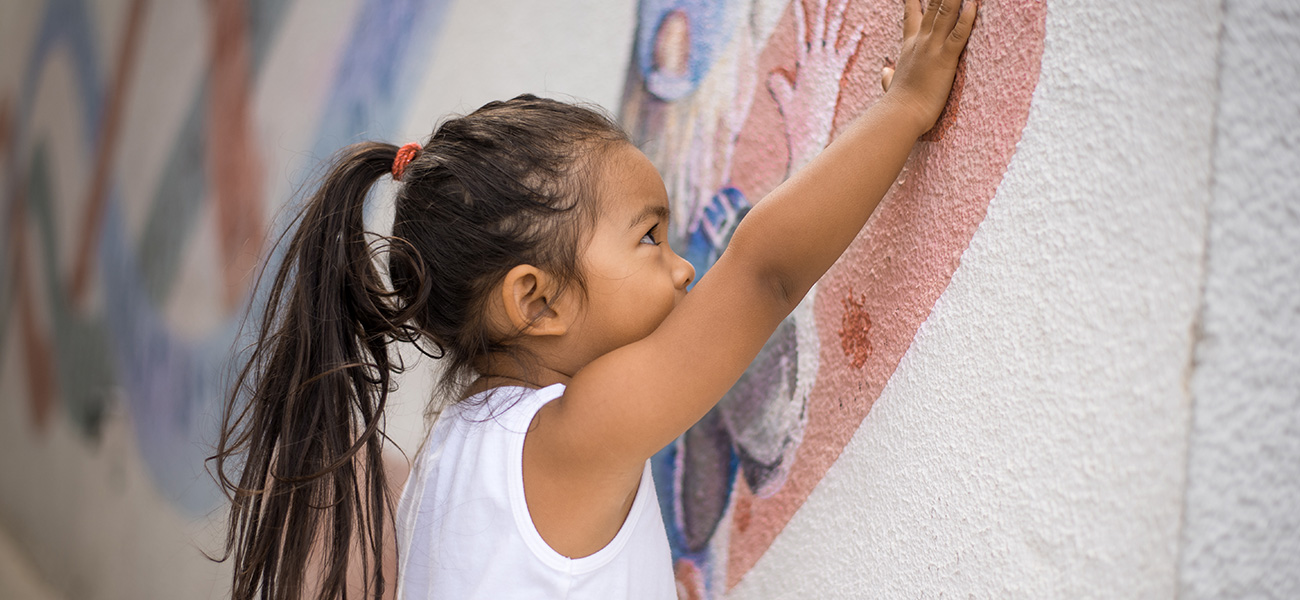 Kid next to wall mural.
